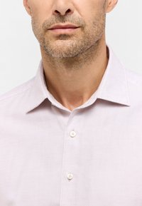 Lichtpaarse button-down blouse met een klassieke kraag, subtiele textuur en parelachtige knopen, geschikt voor zowel casual als formele gelegenheden.