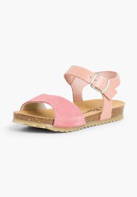 Pink suede sandal with an ankle strap and silver buckle, featuring a contoured cork footbed and a flexible, textured rubber sole.