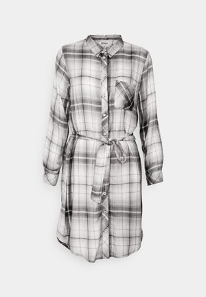 Svart-hvitt rutete skjortekjole med lange ermer, brystlomme og belte i livet, laget av lett stoff.