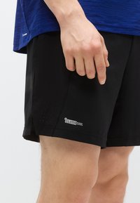 Čierne športové šortky z priedušnej tkaniny, s perforovanými detailmi a našitou značkou "ClimaCool" blízko lemu.