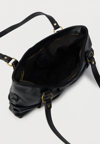 Sac à main en cuir noir à la texture douce, fermoir zippé et accents en métal doré. Intérieur en tissu noir avec un espace généreux pour les effets personnels.