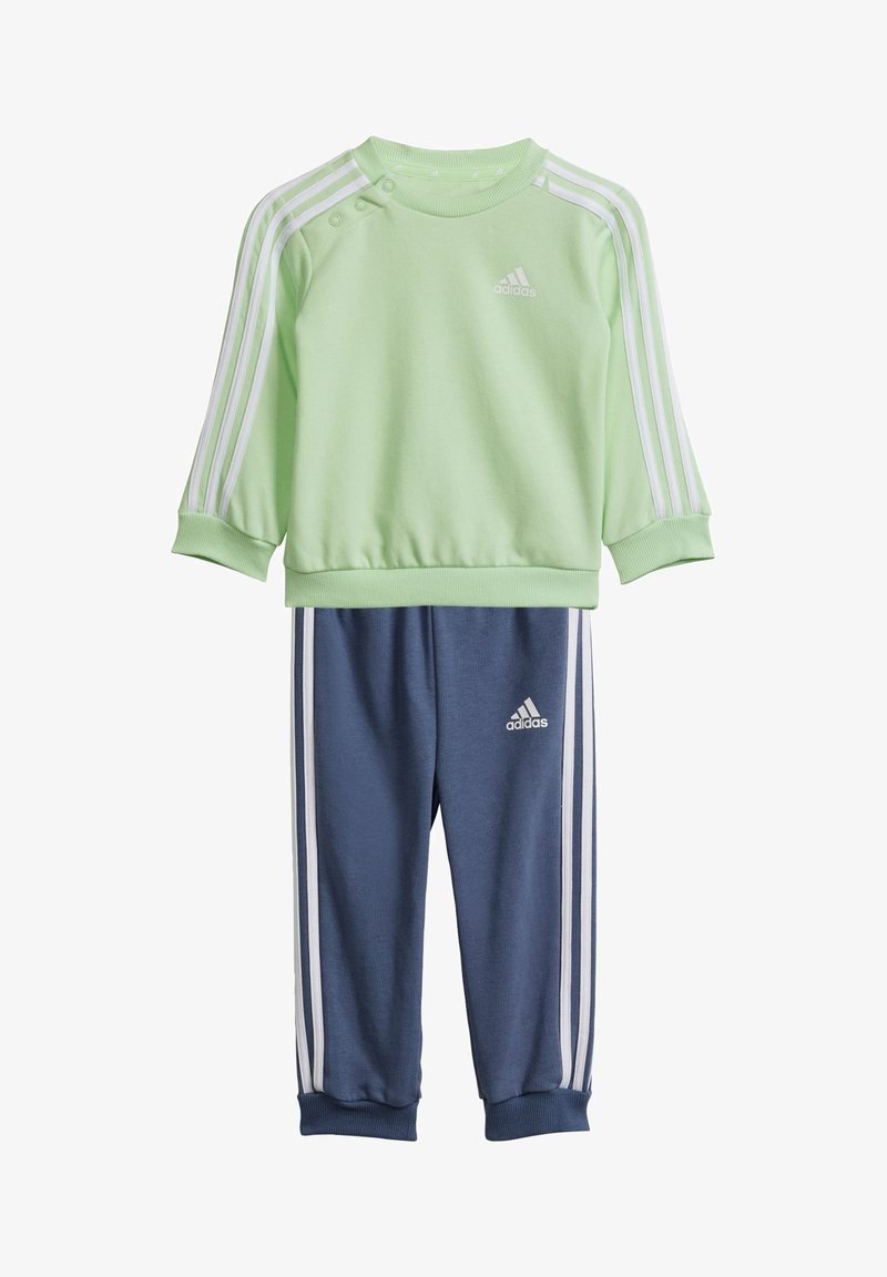 Sudadera verde con rayas blancas y botones a presión en los hombros, combinada con pantalones de chándal azul marino que tienen rayas blancas y un logo.