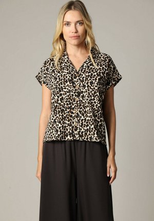 Chemise à manches courtes en imprimé léopard avec col, fermeture à boutons et coupe décontractée. Fabriquée en tissu léger, elle présente des couleurs noire et beige.