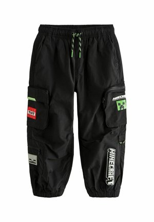 Pantalon cargo noir avec taille et poignets élastiques, orné de patchs à thème Minecraft, incluant un bloc TNT et un visage de Creeper, ainsi que des cordons d'ajustement avec accents verts.
