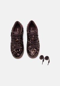 Sneakers neri con paillettes che presentano una tomaia in suede, punta tonda e lacci piatti, accompagnati da un paio extra di lacci coordinati.