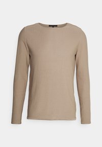 Haut à manches longues de couleur marron clair, confectionné en maille douce, avec un col rond et des coutures minimales, présentant une texture lisse et une coupe ajustée.