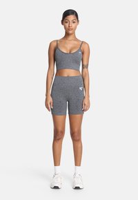 Sivý športový set obsahujúci krátky top s tenkými ramienkami a šortky s vysokým pásom. Tkanina má textúrovaný vzor. Biela značka detail.