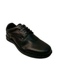 Zapato de cuero negro con puntera redonda, diseño de cordones, costuras visibles y perfil bajo. Textura suave con acabado pulido.