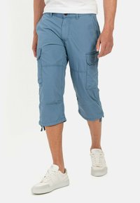 Light blue cargo shorts made from lightweight fabric. Feature multiple pockets, knee-length cut, and adjustable drawstring hems.