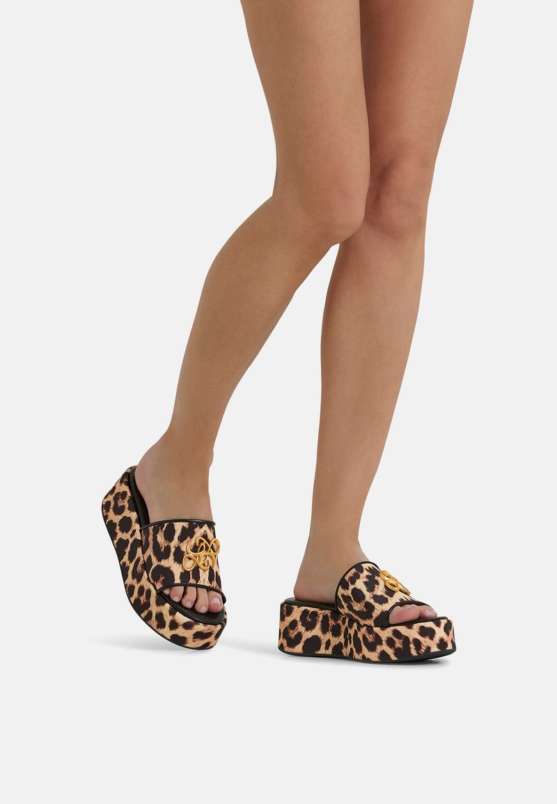Le sandali a piattaforma con stampa leopardo presentano un bordo nero e dettagli in oro, con un design aperto sulla punta e un tessuto testurizzato per il comfort.