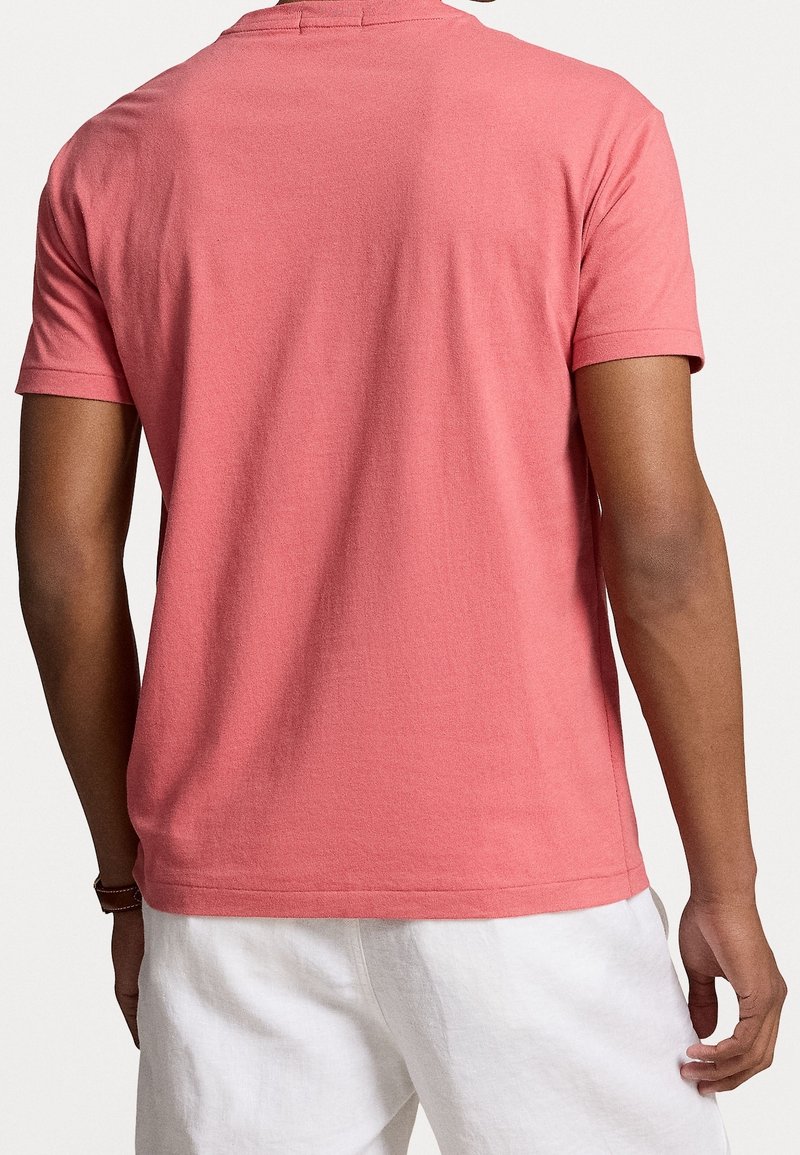 Kurzärmliges T-Shirt mit Rundhalsausschnitt in Korallenpink, aus weichem Baumwollstoff, mit glattem Textil und lockerer Passform.