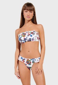 Bikini set s gornjim dijelom bez naramenica i volanima, s brokatnim cvjetnim uzorkom na bijeloj pozadini.