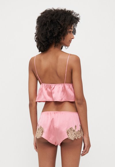 Roze satijnen bralette met een gerimpelde zoom, verstelbare bandjes, gecombineerd met bijpassende shortjes met kantaccenten aan de zijkanten.