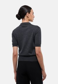 Polo gris à manches courtes en maille lisse, avec un col classique et un ourlet côtelé, présenté de dos.