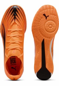 Scarpe sportive arancioni brillanti con una tomaia testurizzata, dettagli neri e particolari bianchi. Presentano una suola sagomata per la trazione e un codice QR all'interno.