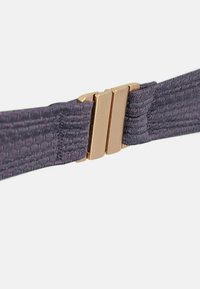 Lilla kootud elastne rihm kuldse tooniga metallkinnitusega, millel on sile tekstuur ja õhuke, ristkülikukujuline kuju.