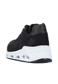 Chaussure de sport noire avec un motif texturé, dotée d'une semelle ondulée blanche et d'accents métalliques. La tige a un design moderne et épuré avec des lacets.