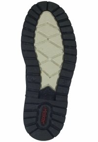 Suela de zapato de goma negra con una superficie texturizada, que presenta un patrón de banda de rodadura en zigzag y un logotipo central. Detalles cóncavos y elevados presentes.