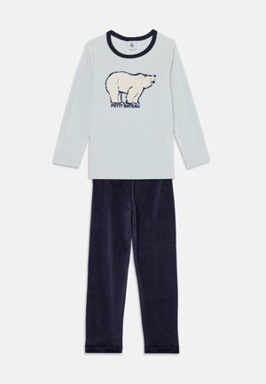 Helles blaues Langarmoberteil mit einem Bären-Graphic und dem Text "Petit Bateau", kombiniert mit weichen dunkelblauen Hosen. Beide aus bequemem Material.