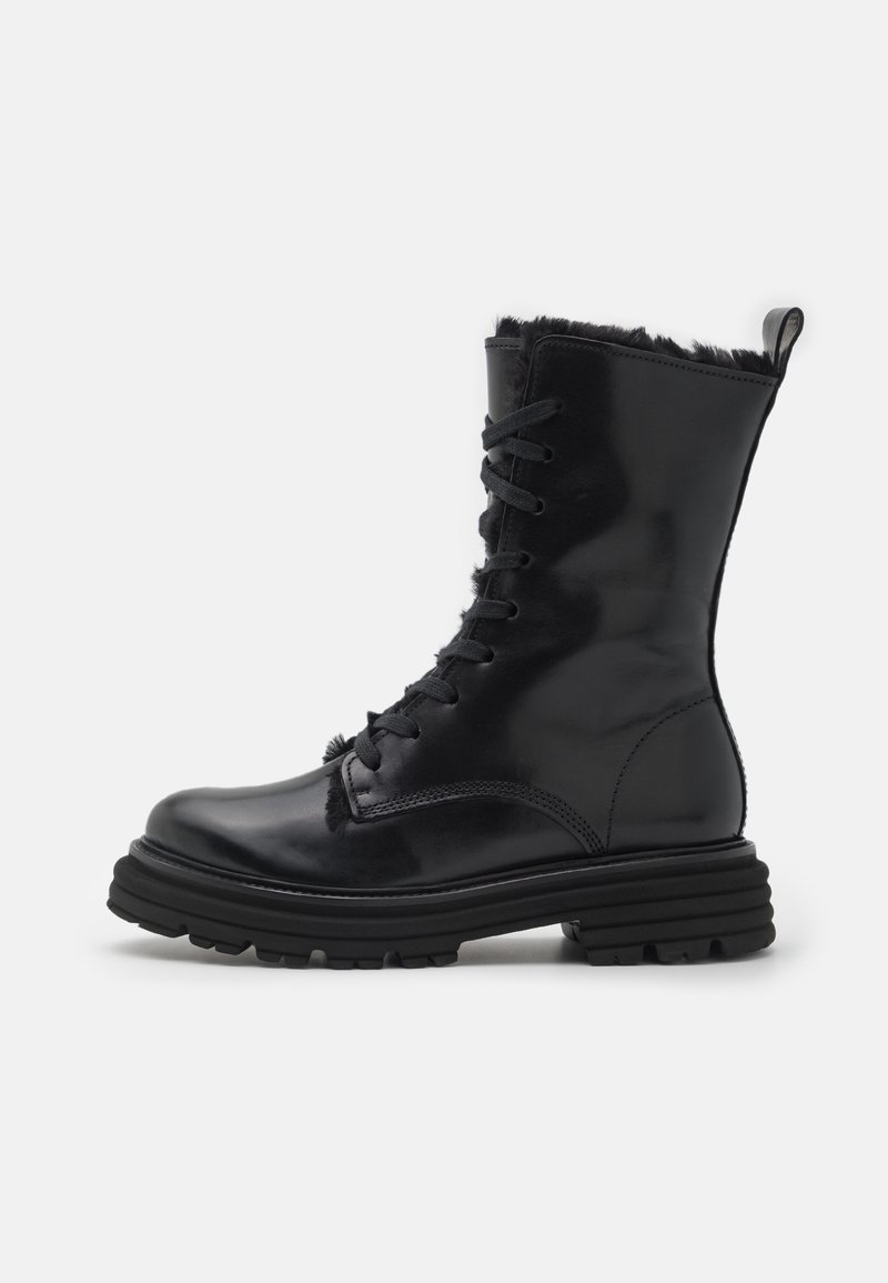 Bottine en cuir noir à lacets, avec une semelle en caoutchouc noir épaisse et une doublure en fourrure texturée sur le haut.