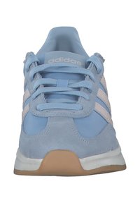 Scarpa sportiva in suede blu chiaro con tre strisce bianche, linguetta ammortizzata e suola in gomma. I lacci sono dello stesso blu chiaro.