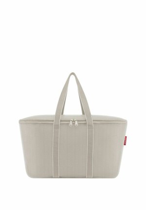 Rectangular beige tote bag with dual handles and a top zipper closure, featuring a small red fabric tag on the side.