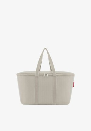 Rectangular beige tote bag with dual handles and a top zipper closure, featuring a small red fabric tag on the side.