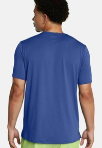 Maglietta sportiva blu a maniche corte realizzata in tessuto liscio e traspirante, con scollatura rotonda e un discreto logo sul retro.