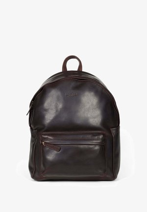 Brązowy skórzany plecak o zaokrąglonym kształcie, z przednią kieszenią na zamek i górnym uchwytem. Gładka tekstura i subtelne wytłoczone logo.