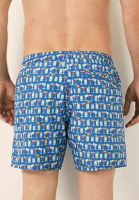 Pantaloni de baie cu un fundal albastru, având un model repetat cu cocktailuri și băuturi colorate. Talie elastică, lungime până la mijlocul coapsei.