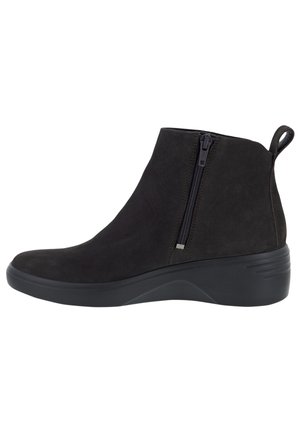 Bottine noire à cheville avec fermeture éclair latérale, languette au talon et semelle compensée basse conçue pour un usage décontracté.