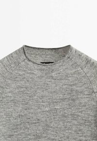 Pull gris clair en maille avec un col rond et des manches raglan, présenté à plat sur un fond blanc.