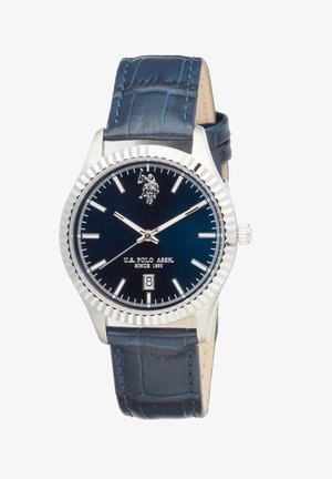Montre-bracelet à bracelet en cuir bleu avec lunette argentée, cadran noir, index horaires blancs, affichage de la date à 6 heures, et logo de l'U.S. Polo Assn. à 12 heures.
