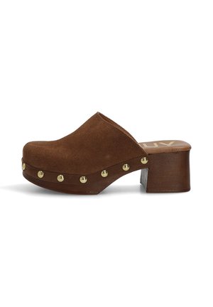 Zueco de ante marrón con tacón de bloque de madera y tachuelas doradas a lo largo de la base, estilo sin cierre, puntera cerrada.