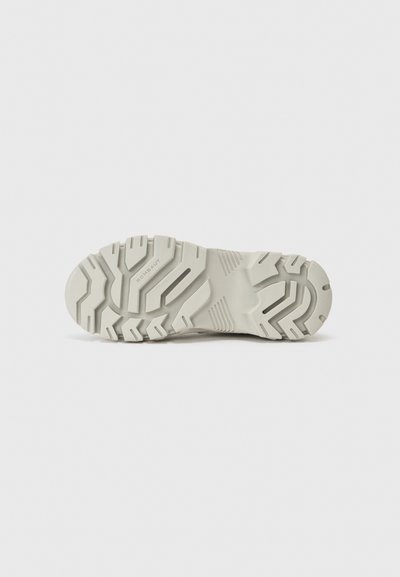 White rubber shoe outsole with a textured grip pattern and prominent tread design. Features brand name "ROMBAUT" on the sole.