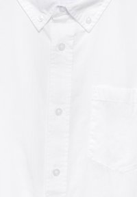 Witte button-up shirt met een puntige kraag, voorzak en heldere kunststof knopen. Gladde katoenen stof, eenvoudig ontwerp, zonder patronen.