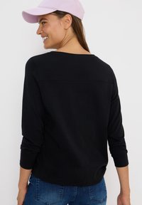 Zwarte langemouwen shirt met een ronde hals en 3/4 mouwen, met een gladde textuur en een eenvoudig, ongecompliceerd ontwerp.