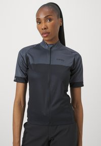 Maillot de cyclisme à manches courtes en gris foncé avec une fermeture éclair sur le devant, présentant une texture contrastante, le logo Giro et un design sportif.