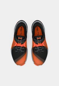 Pair of black and orange athletic shoes with gray accents and patterned laces, viewed from above on a white background.