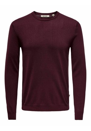 Maglione bordeaux a girocollo realizzato in morbido tessuto a maglia, con maniche lunghe e orlo a coste. Design minimalista con etichetta dettagliata sul lato.