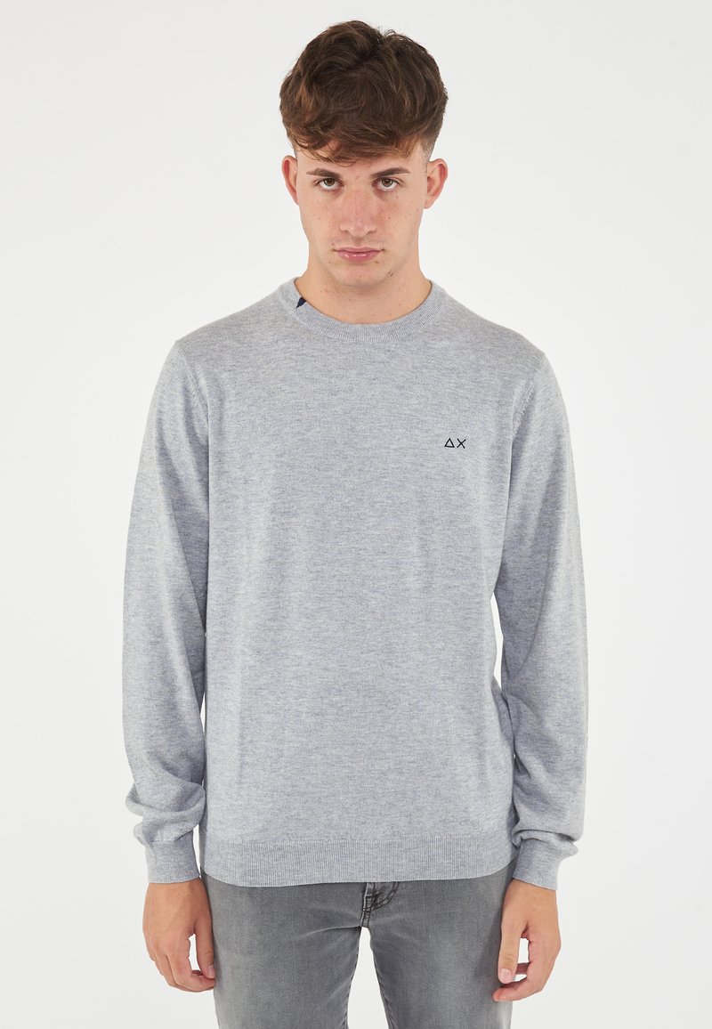 Maglione grigio realizzato in tessuto a maglia morbido, dotato di scollatura rotonda, maniche lunghe e un piccolo logo sul petto. Vestibilità casual.