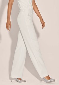 Witte op maat gemaakte broeken met een rechte pijpontwerp, voorzien van zijzakken en een gladde stoftextuur, gecombineerd met zilveren hoge hakken.