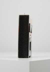 Black glitter-covered item shaped like a small figure with glasses, featuring a smooth, shiny surface on the front and a matte black back.