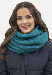 Eșarfă tricotată de culoare teal, cu o textură groasă, înfășurată de mai multe ori în jurul gâtului, având un mic accent din piele.
