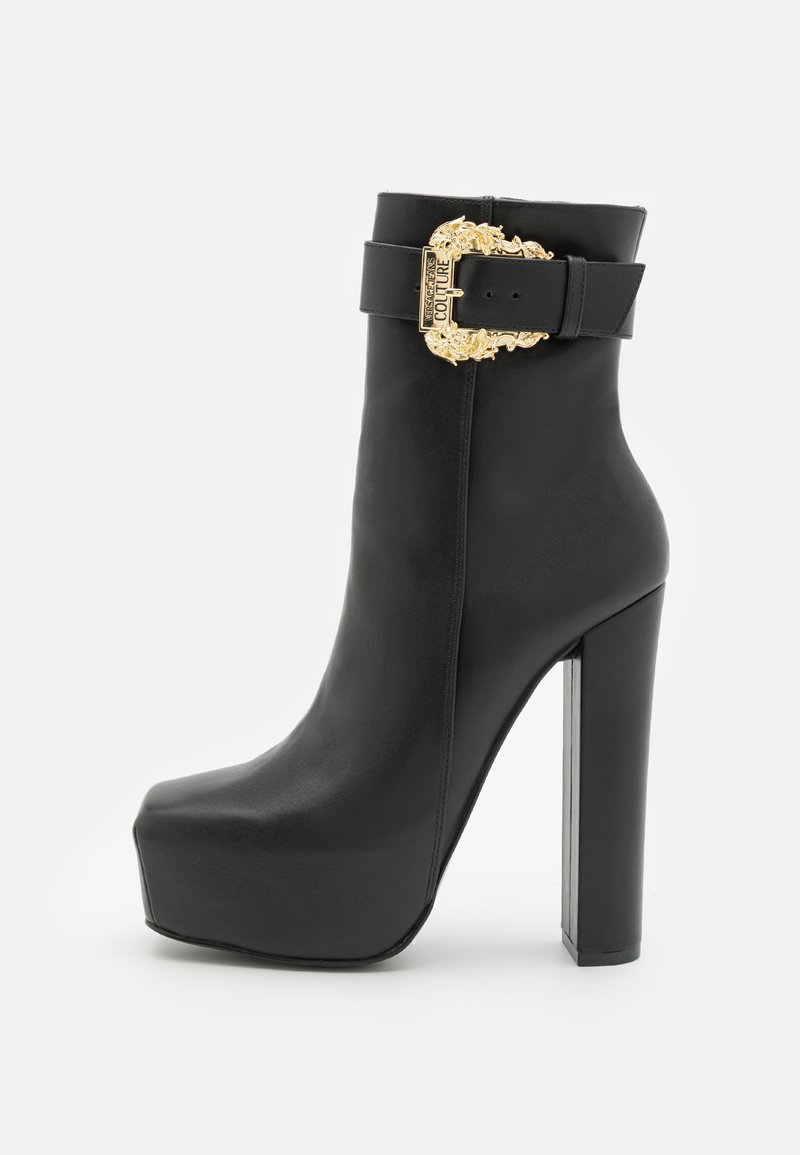 Stivale alla caviglia in pelle nera con tacco a blocco alto, suola con platfrm e cinturino largo con una fibbia decorativa dorata. Texture liscia, design aderente.