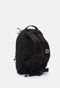 Zaino nero con spallacci imbottiti, tessuto testurizzato, patch logo frontale e cinturini laterali regolabili per una chiusura sicura.
