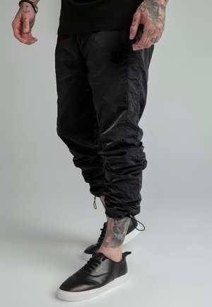 CRUSHED PANTS - Tracksuit bottoms - black