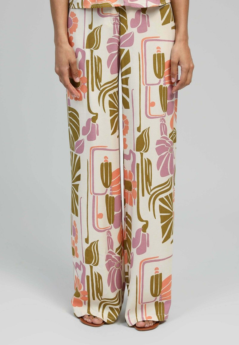 Pantalons larges en tissu crème présentant un motif floral et géométrique multicolore dans les tons rose, orange et vert. Texture lisse, longueur cheville.