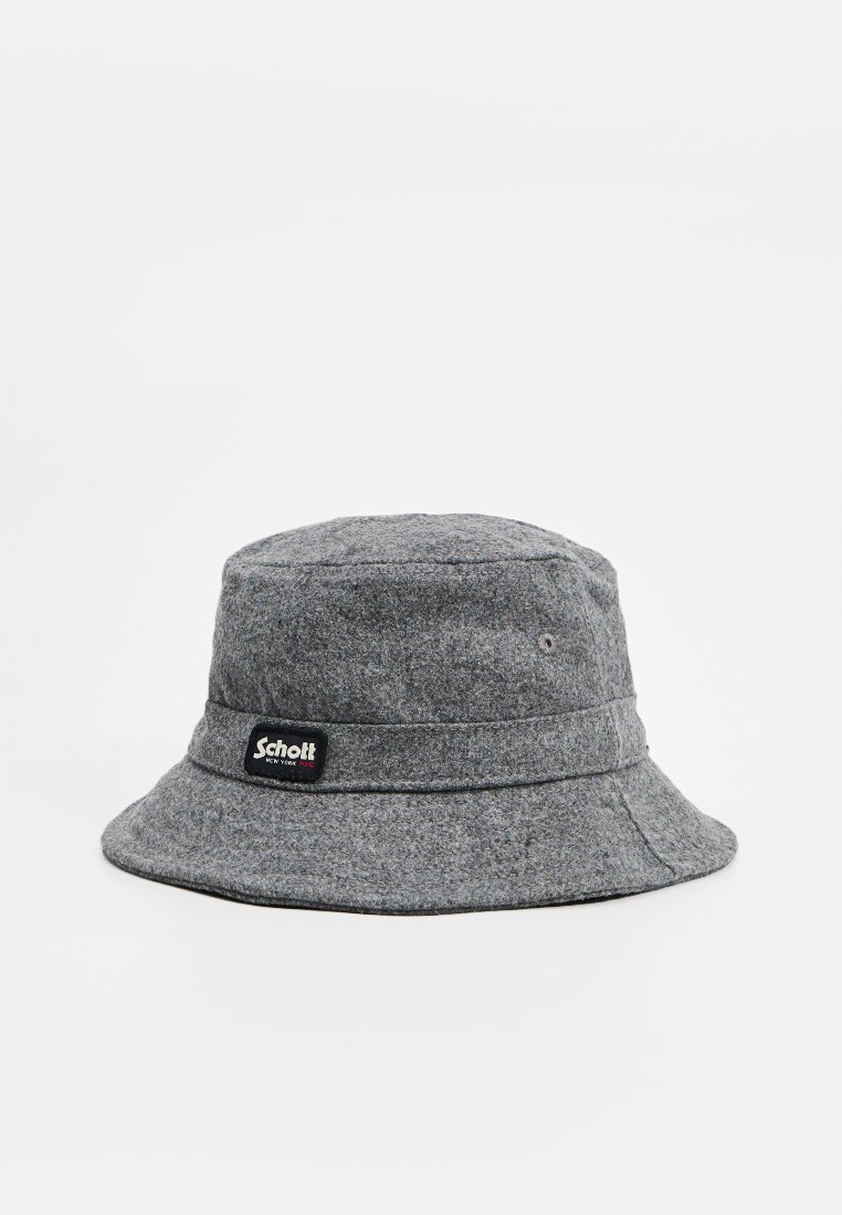 Cappello a secchi grigio con una larga visiera, dotato di un'etichetta nera con testo bianco su un lato, che mostra una superficie testurizzata.