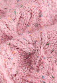 Tessuto lavorato a maglia morbido di colore rosa con un motivo spesso e strutturato, arricchito da punteggiature colorate di verde, blu e arancione distribuite ovunque.